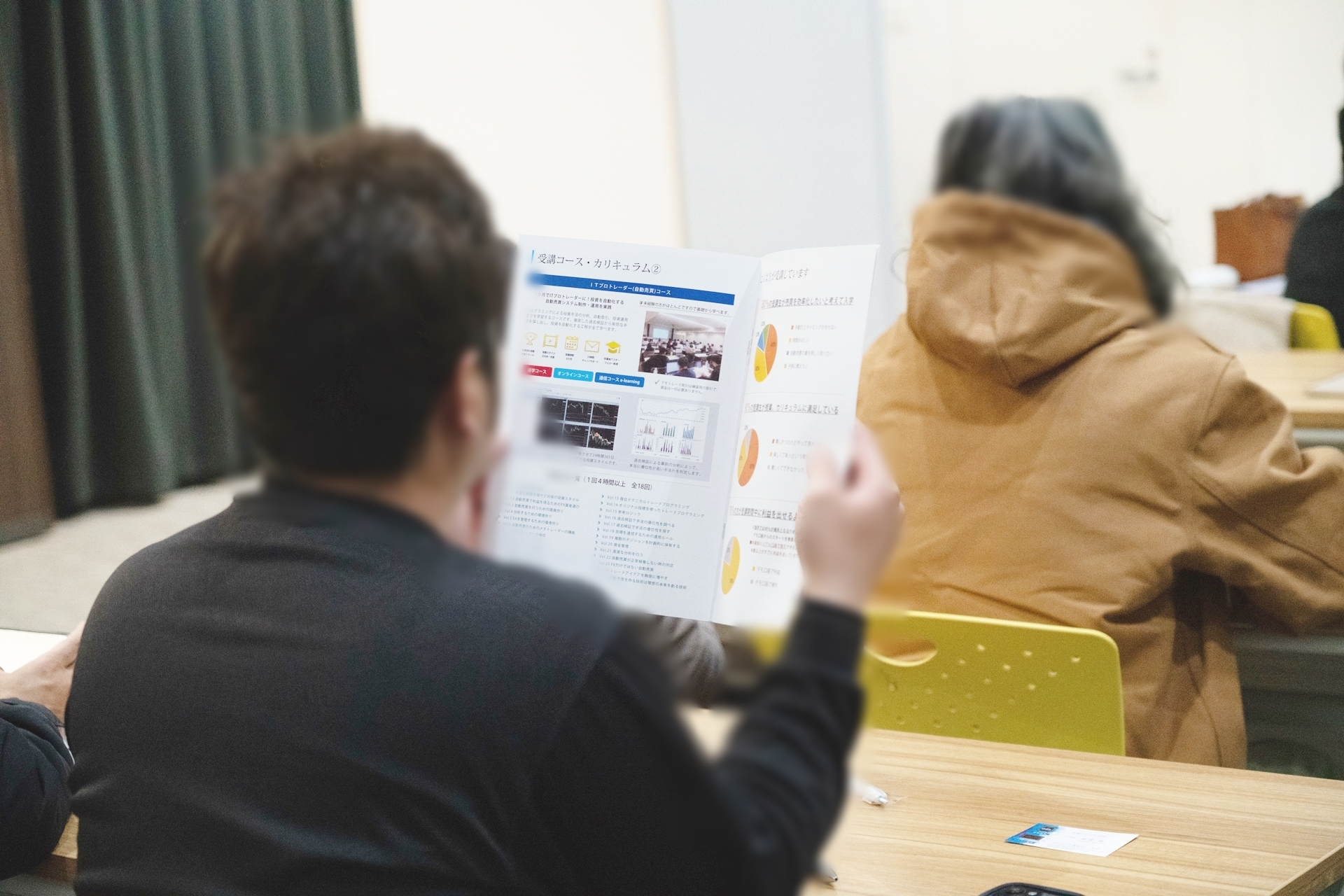 沖縄トレード学院の入校案内を読む受講生